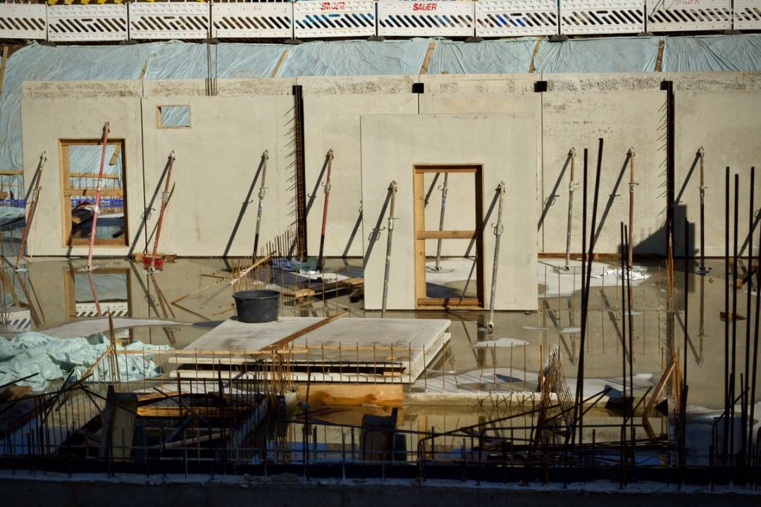 Aufgestellte Betonwandelemente mit Fenster und Türöffnungen, mit Schrägstützen gesichert